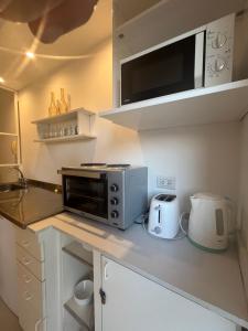a kitchen with a microwave and a coffee maker on a counter at Amplio,cómodo,moderno y céntrico monoambiente. in Paraná