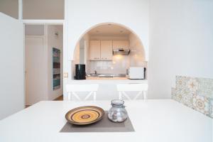 a white kitchen with a table with a plate on it at Panoramic App B06-1 in Sierksdorf
