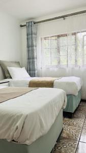 a bedroom with two beds and a window at Sibusi Guesthouse in Richards Bay