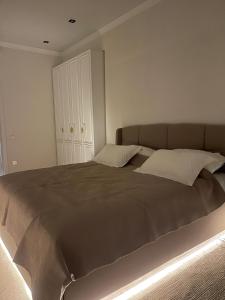 a bedroom with a large bed with two pillows at Apartment Bay Tash Tower in Bishkek