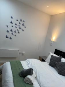 Un dormitorio con una cama con pájaros en la pared. en Elegant Apartment in Central Milton Keynes, en Milton Keynes