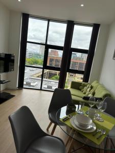 Una sala de estar con una mesa y sillas y una gran ventana. en Elegant Apartment in Central Milton Keynes, en Milton Keynes