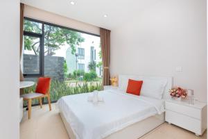 ein Schlafzimmer mit einem weißen Bett und einem großen Fenster in der Unterkunft VILLA ARIA RESORT, THE SEA BY 10-50m,Biển và hồ bơi riêng in Vũng Tàu + 228 Fotos