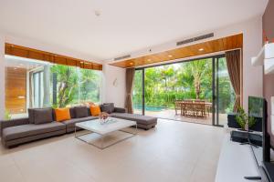 ein Wohnzimmer mit Sofa und Tisch in der Unterkunft VILLA ARIA RESORT, THE SEA BY 10-50m,Biển và hồ bơi riêng in Vũng Tàu