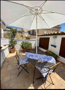 a table and chairs with an umbrella on a patio at Residenza Teseo in Siracusa