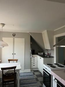 a kitchen with white cabinets and a table in it at Vinberga in Enhörna