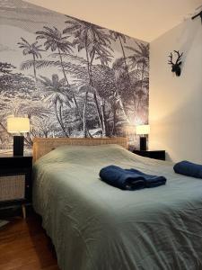 ein Schlafzimmer mit einem Bett mit einem Palmenmilch in der Unterkunft L'écrin des Tanneurs - 110m2 - 2 chambres - Epernay Hyper Centre in Épernay