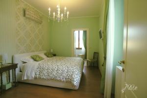 1 dormitorio con cama y lámpara de araña en Luxury B&B '700 en Ascoli Piceno