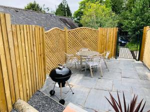un cortile con griglia, tavolo e sedie di Mount Cottage a Newcastle Emlyn