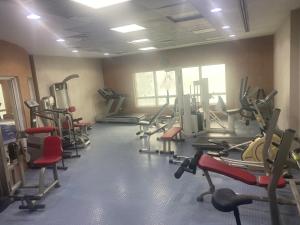 una palestra con diversi tapis roulant in una stanza di DELUXE Studio Apartment a Sharjah