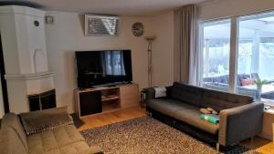a living room with a couch and a tv at Spacious villa in a quiet area in Fellingsbro