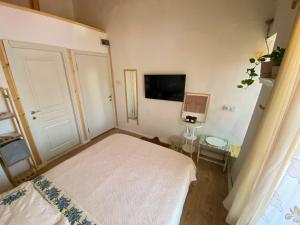 Un dormitorio con una cama blanca y un televisor. en esket alaçatı, en Alacati 51 fotos más