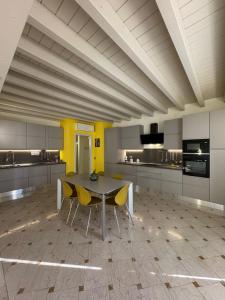 a large kitchen with a table and yellow chairs at Casa degli Angeli in Casalmoro +15 photos