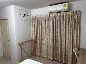 ナイヤンビーチにあるSleepwell at naiyang No2の壁掛け時計付きの部屋
