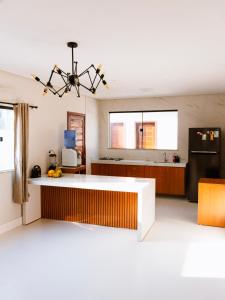 a kitchen with a white counter and a black refrigerator at Casa Fênix - Casa de Temporada nos Lençóis Maranhenses in Barreirinhas