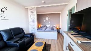 een woonkamer met een bank en een bed bij Harztraum in Altenau