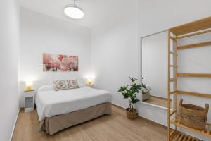 Un dormitorio blanco con una cama y un espejo. en Urban Chic Oasis with AC, Private Pool and Wifi, en Alicante