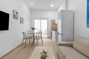 Una sala de estar con un sofá, una mesa y sillas. en Urban Chic Oasis with AC, Private Pool and Wifi, en Alicante