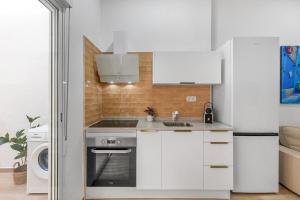 Una cocina blanca con fregadero y estufa. en Urban Chic Oasis with AC, Private Pool and Wifi, en Alicante 10 fotos más