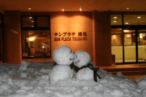 two snow men kissing in a pile of snow at Hotel Sunplaza Tsugaike in Otari