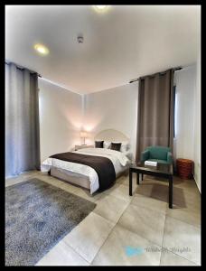 a bedroom with a bed and a table and a chair at Weibdeh Heights Hotel Suites in Amman