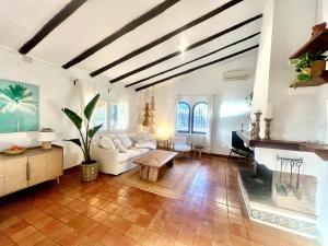 a living room with a white couch and a fireplace at Finca es Born - vistas panorámicas in Esporles