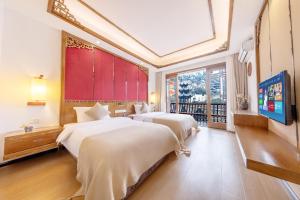 镇远县Wushiju丨Zhenyuan Ancient City Riverside B&B的一间卧室设有两张床和大窗户