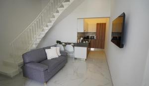 a living room with a couch and a staircase at Viktorja106 in Senglea