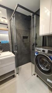 a washing machine in a kitchen with a sink at Słoneczna 3m5 in Gorlice +5 photos