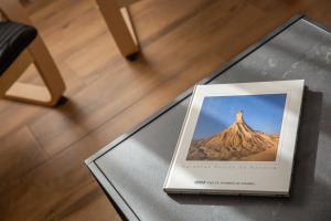 ein Buch auf einem Tisch mit einem Bild eines Berges in der Unterkunft Casa Tierra Viva, junto a Bardenas Reales y Sendaviva in Valtierra