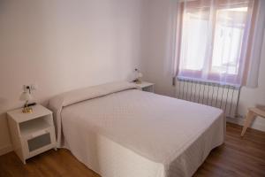 ein Schlafzimmer mit einem weißen Bett und einem Fenster in der Unterkunft Casa Tierra Viva, junto a Bardenas Reales y Sendaviva in Valtierra