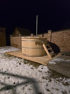 a wooden tub sitting on top of a wooden deck at Antal Guesthouse in Ghimeş-Făget