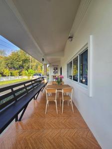 eine Veranda mit einem Holztisch und Stühlen darauf in der Unterkunft Chaba4-1 in Ban Nong Bua Noi