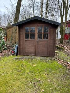 un garage in legno con una porta nell'erba di 104 smarttv xbox restaurant playyard P keybox airco starlink forest pets pittoresque a Uelsen