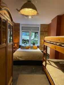 Un dormitorio con una cama y una ventana grande. en Berthe Artist House, en La-Roche-en-Ardenne