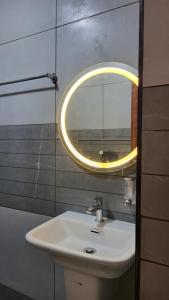 bagno con lavandino e specchio a parete di Hill View Homes,AC Suites in trivandrum a Trivandrum