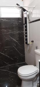 a bathroom with a toilet and a black wall at San Vicente - Misiones in San Vicente