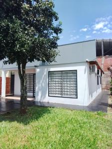 a white building with a tree in front of it at San Vicente - Misiones in San Vicente