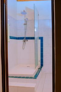 una ducha con puerta de cristal en un baño en Quality Inn Motel, Nyanza, en Gahondo 87 fotos más