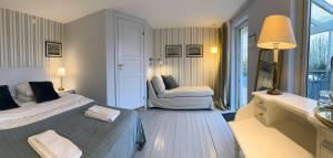 a bedroom with a bed and a chair in it at Villa Beddingestrand in Beddinge Strand