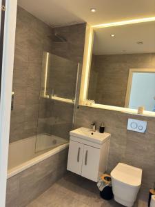 Un baño con inodoro, lavabo y ducha. en Elegant Apartment in Central Milton Keynes, en Milton Keynes