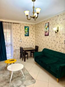 a living room with a green couch and a table at Haven Hub B22 in Kampala