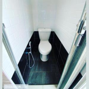 une petite salle de bain avec toilettes et douche dans l'établissement Kawaii Homestay Kuala Terengganu, à Kuala Terengganu 11 autres photos