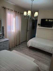 a bedroom with two beds and a tv on the wall at Casa Amalia in Agulo