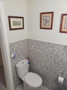 a bathroom with a toilet and some pictures on the wall at Casa Amalia in Agulo
