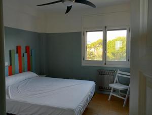 una camera da letto con un letto e un ventilatore a soffitto di Aloha Miami a Miami Platja