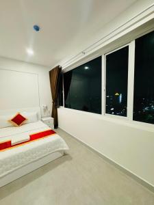 une chambre avec un lit et une grande fenêtre dans l'établissement Phú Gia 2307 Huỳnh Tấn Phát, à Hô-Chi-Minh-Ville