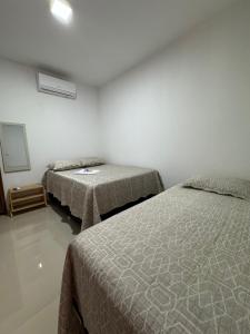 a bedroom with two beds and a mirror at Recanto dourado Suíte 5 in São Miguel dos Milagres