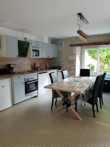 a kitchen with a table and chairs and a kitchen with white cabinets at Gîte avec vue in Hautefage-la-Tour +6 photos