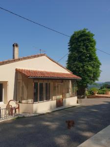 a dog standing in front of a house at Gîte avec vue in Hautefage-la-Tour